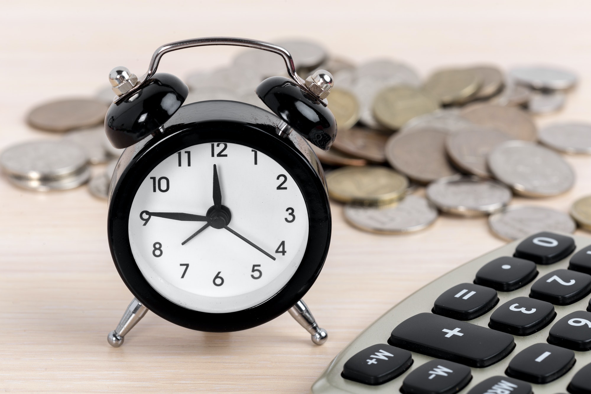 Alarm clock and coins on white background
